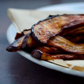 Foto van bacon op basis van aubergine, opgestapeld op een bord