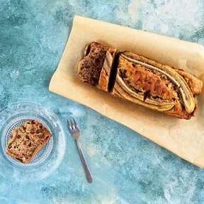 Foto van bananenbrood met een losse plak op een schaaltje