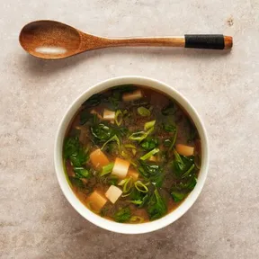 Foto van een kom met Koreaanse soep met tofu en spinazie