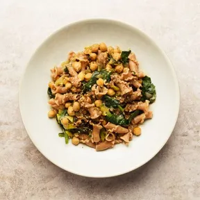 Foto van een bord volkorenpasta met kikkererwten, spinazie en za'atar