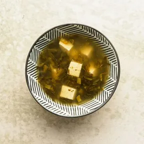 Foto van een kommetje met Sichuan tofusoep met ingelegde mosterkoolbladeren