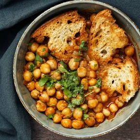 Foto van tunesische kikkererwten stoofpot (Lablabi) met geroosterd brood en gehakte koriander