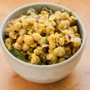 Foto van een schaaltje met een plantaardig alternatief voor kip kerrie salade op basis van kikkererwten